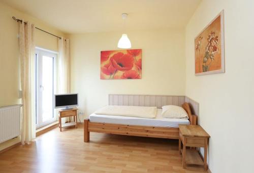 um quarto com uma cama e uma televisão em Backerwirt - Wohnen und Schlafen em Welden