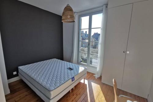 Schlafzimmer mit einem Bett vor einem Fenster in der Unterkunft La Maison de Timothée 11 couchages in Reims