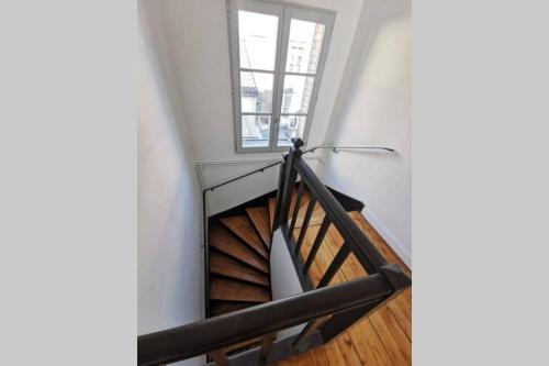 - un escalier en colimaçon dans une chambre avec fenêtre dans l'établissement La Maison de Timothée 11 couchages, à Reims