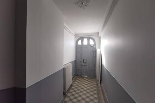 a hallway with a door and a tile floor at La Maison de Timothée 11 couchages in Reims