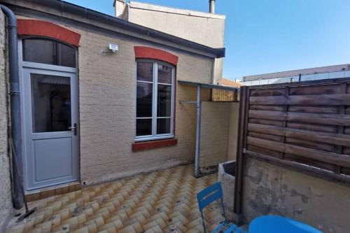 a building with a white door and a fence at La Maison de Timothée 11 couchages in Reims