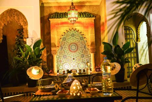 a dining room with a table with a patterned wall at Riad Al mazhar in Rabat