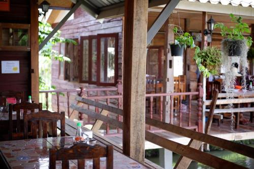 a restaurant with a table and chairs on a balcony at Huean Himbo in Chiang Rai