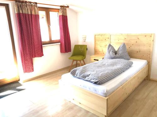 a bedroom with a bed and a green chair at Gästehaus Brigitte in Garmisch-Partenkirchen