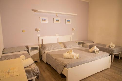 ein Zimmer mit 2 Betten und Handtüchern darauf in der Unterkunft Hotel Arlecchino Riccione in Riccione