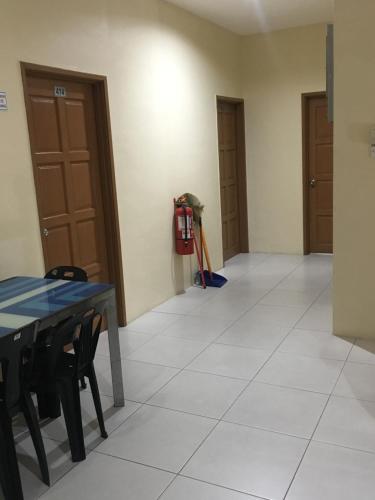 a room with a table and chairs and a fire extinguisher at Motel Fasa2B in Seri Manjung