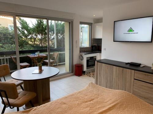 ein Wohnzimmer mit einem TV an der Wand in der Unterkunft LE GRAND LARGE in Sainte-Maxime