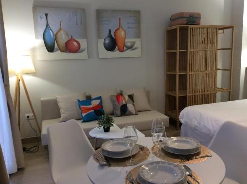 a living room with a table and a couch at Apartamentos turísticos CASA de los BALCONES in Chipiona