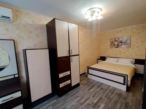 a bedroom with a bed and a large cabinet at ДЕНЬ И НОЧЬ Ленина, 40 in Kaluga