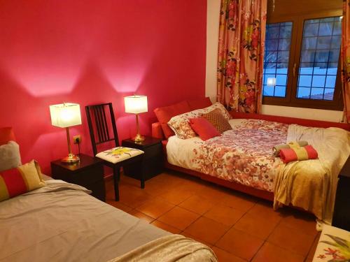 a bedroom with two beds and pink walls at Ashram Villa Sunshine in Sitges