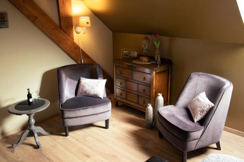 a living room with two chairs and a dresser at B&B 't Inj in Horn