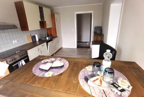a kitchen with a wooden table with two plates on it at Apart Oderblick in Neubleyen