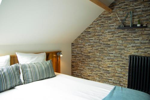 a bedroom with a bed with a brick wall at B&B 't Inj in Horn