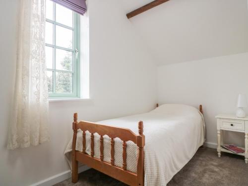 a bedroom with a bed and a window at Ostlers in Mitcheldean