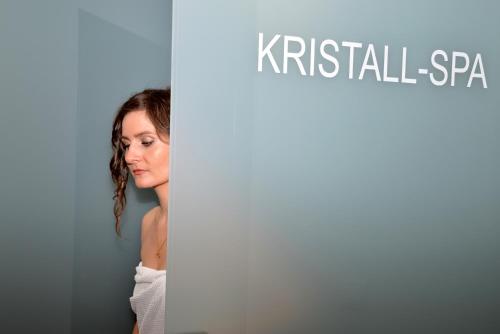 a woman standing next to a sign that reads kristall spa at Das Tannberg in Lech am Arlberg