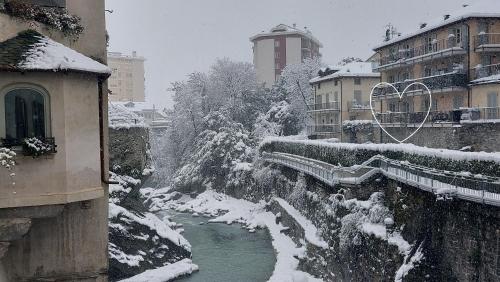 a river in a city covered in snow at Chiavenna Suite in Chiavenna