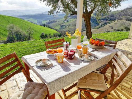 un tavolo con colazione a base di frutta e succo d'arancia di La mia Casa nelle Marche a Ripatransone