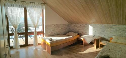 1 dormitorio con cama y ventana grande en Nocleg Hotel Nad Stawami, en Brzostek