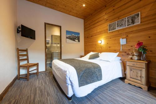a bedroom with a bed, chair, desk and a lamp at La Pointe Percée in Le Grand-Bornand