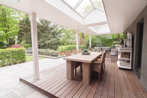 a conservatory with a table and chairs on a deck at B&B Het Zonnehuis Boxtel in Boxtel