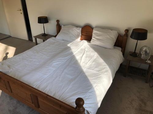 a large bed with white sheets and pillows at B&B Het Zonnehuis Boxtel in Boxtel