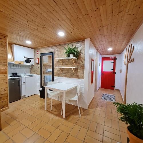 una cocina con una mesa blanca y una puerta roja en Casas Alba Odeceixe, en Odeceixe