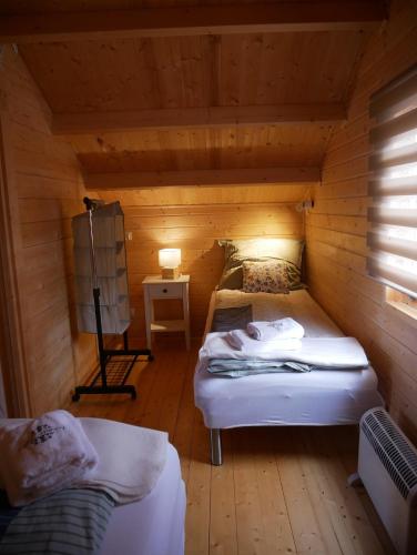 a room with two beds in a wooden cabin at Kaszubskie Wzgórze - Całoroczne Domki Drewniane in Perlino