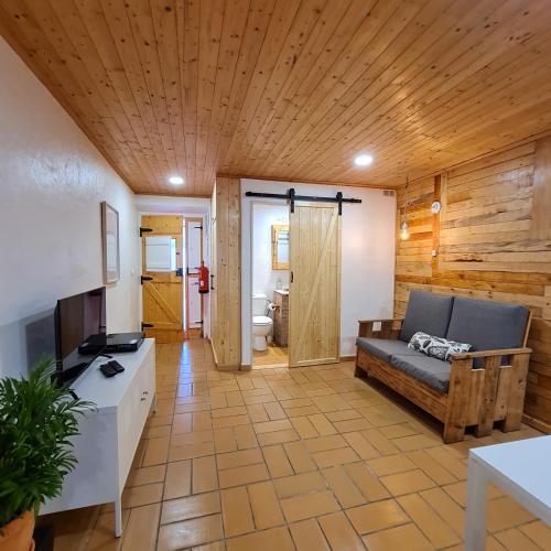 a living room with a couch and a television at Casas Alba Odeceixe in Odeceixe