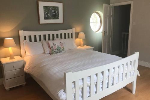 a bedroom with a white bed with two night stands and two lamps at Canal bank house in Bellanaboy