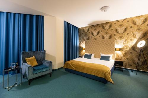a hotel room with a bed and a chair at Royal International Leipzig in Leipzig