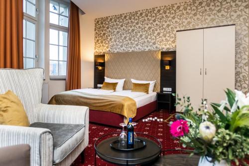 a hotel room with a bed and a couch at Royal International Leipzig in Leipzig