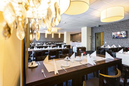 a dining room with a long table and chairs at Royal International Leipzig in Leipzig