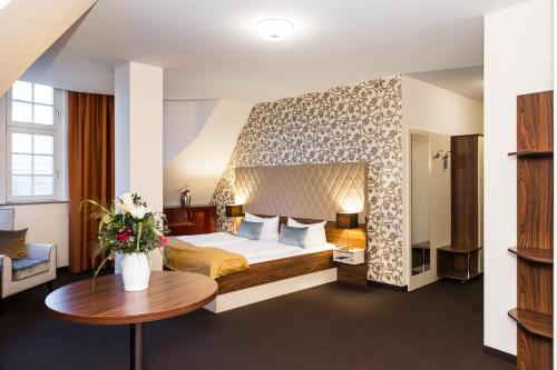 a hotel room with a bed and a table at Royal International Leipzig in Leipzig