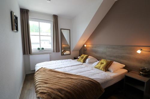 a bedroom with a large bed with a wooden headboard at UplandParcs Residence Astenberg in Winterberg