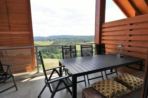 a table and chairs on a balcony with a view at UplandParcs Residence Astenberg in Winterberg