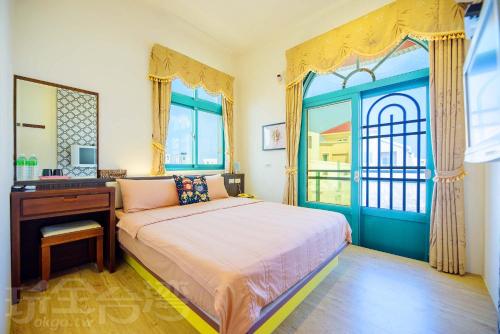 a bedroom with a bed with a desk and a window at All is good B&B in Magong