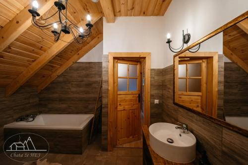 a bathroom with a sink and a bath tub and a mirror at Chata że HEJ in Bukowiec