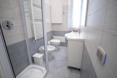 La salle de bains est pourvue de toilettes, d'un lavabo et d'une douche. dans l'établissement Noliday Suite Riviera Luxury Sea Flat, à Noli