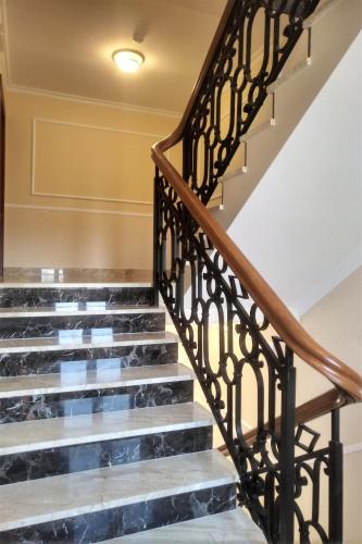a set of stairs with wrought iron railings at Apartamenty Ucho Igielne in Sandomierz