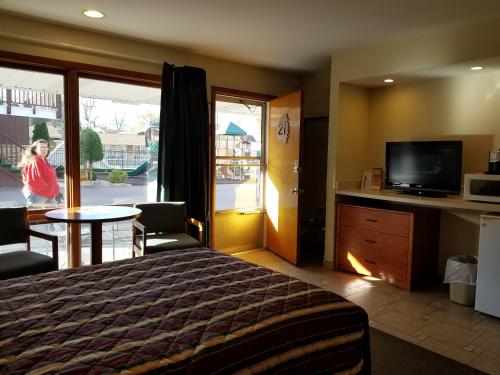 una camera d'albergo con un letto, un tavolo e una televisione di Black Hawk Motel & Suites a Wisconsin Dells