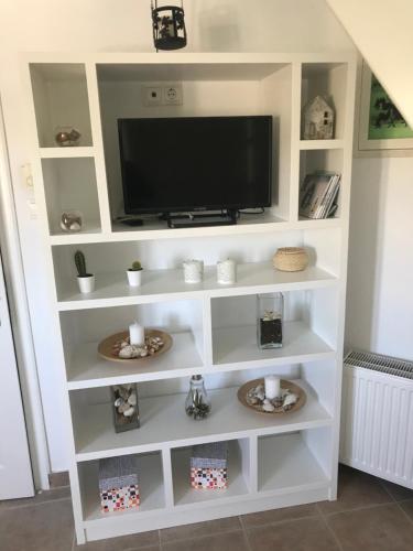 a white entertainment center with a flat screen tv at Romantic loft 1 in Ios Chora