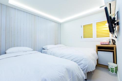 a room with two beds and a tv in it at Hotel Gaon Seoul Dongdaemun in Seoul