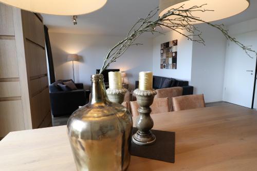 a table with a bottle and two vases on it at UplandParcs Residence Astenberg in Winterberg