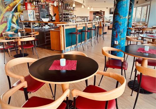 a restaurant with tables and chairs and a bar at Highway Hotel in Herbolzheim