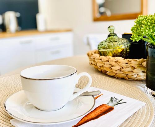 a cup of coffee and a carrot on a table at Cesis Boulevard Apartments in Cēsis