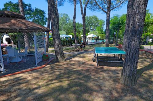 un tavolo da ping pong e un gazebo con alberi di Villa Rossana a Cenaia