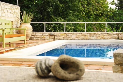 a swimming pool with two balls in front of it at Villa Irini in Vafés