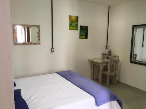 a bedroom with a bed and a table with a mirror at Pousada Brisa e Mar in Praia do Frances
