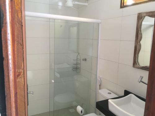 a bathroom with a shower and a toilet and a sink at Pousada Brisa e Mar in Praia do Frances