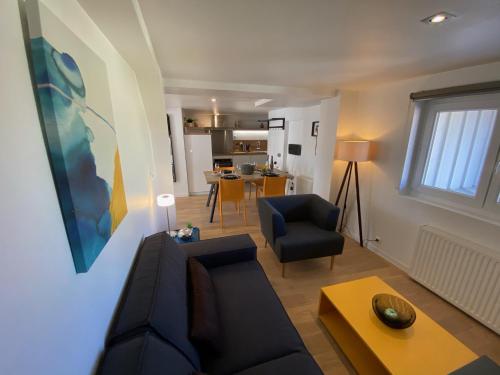 uma sala de estar com um sofá e uma mesa em DUPLEX Le 12 - Appartement avec terrasse dans le vignoble - 5 mn du centre de Colmar em Wettolsheim